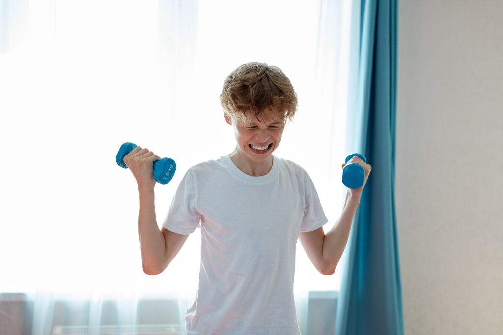 Child, teen boy lifting weights, exercising