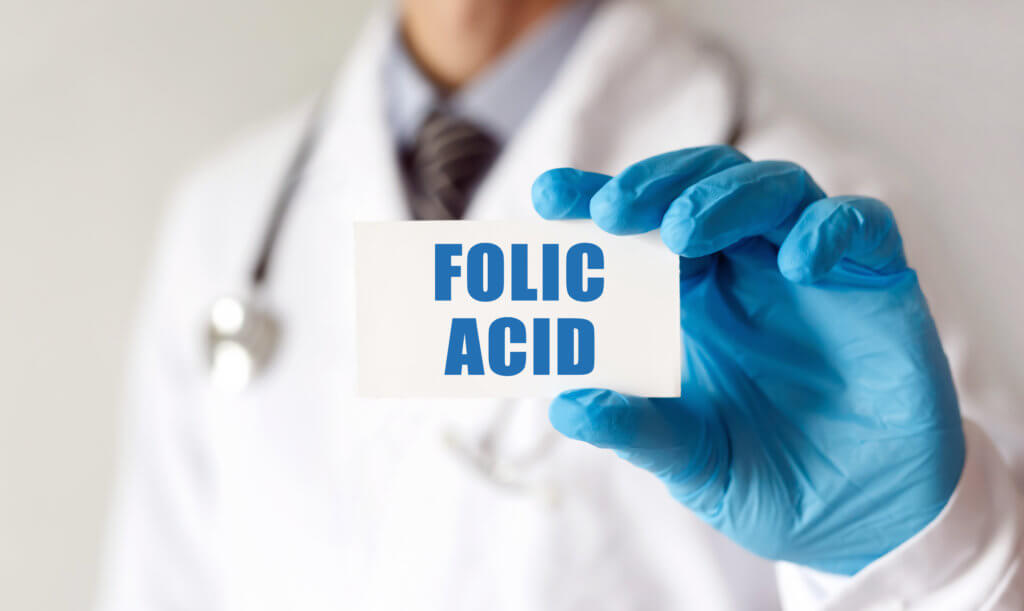 Doctor holding a card with text Folic Acid