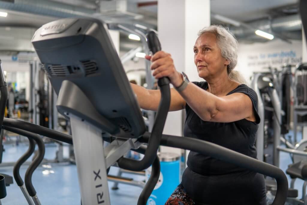 Older woman exercising on elliptical machine
