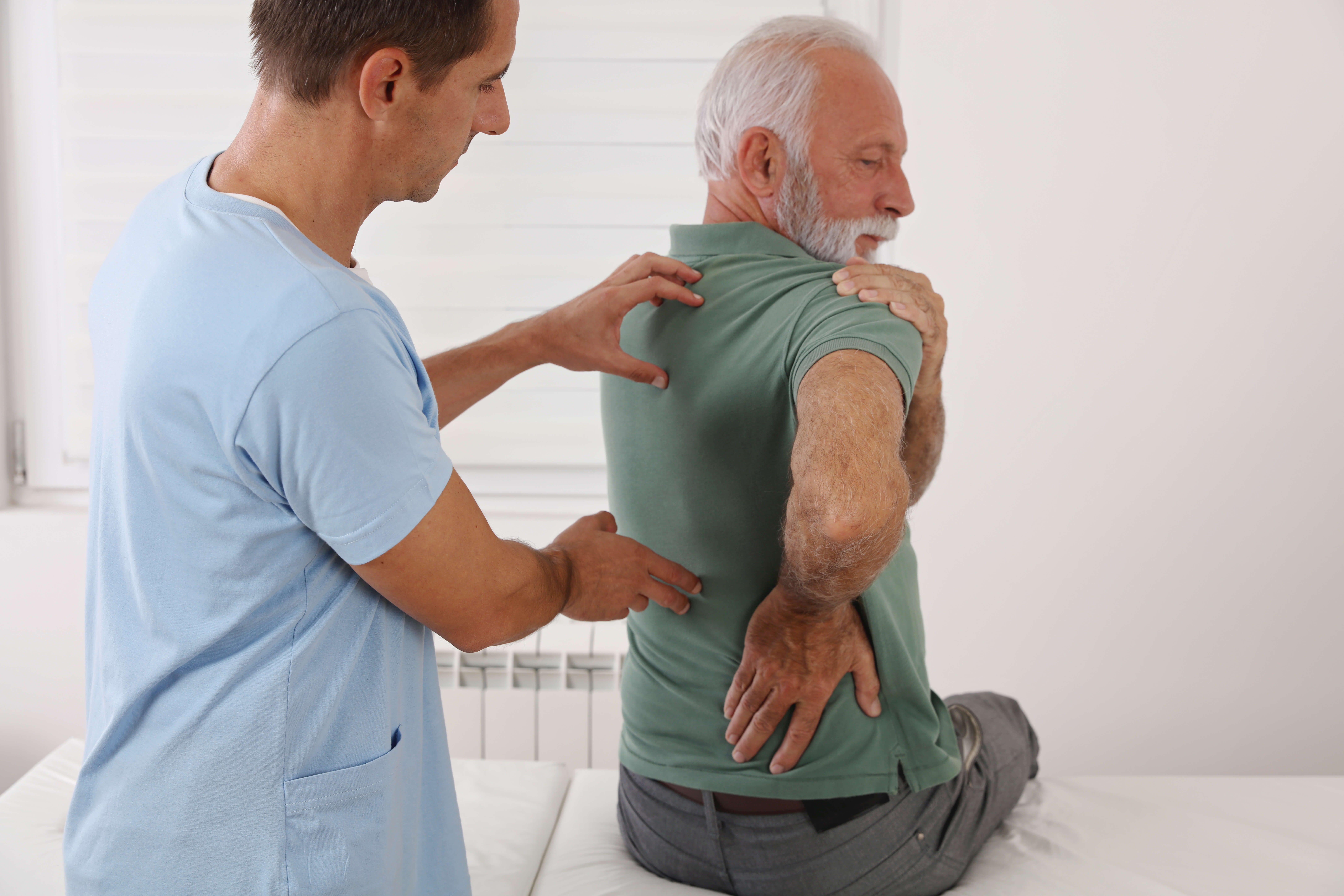 Man with back pain being helped by doctor