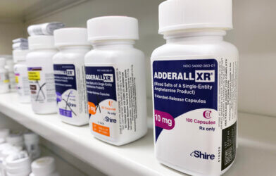 Bottles of ADHD drug Adderall on a pharmacy shelf.