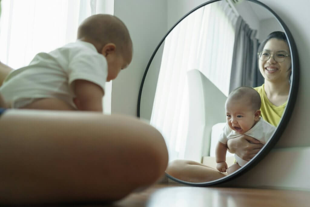Baby and mother looking in mirror