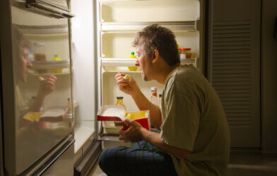 Hungry man raiding the refrigerator for a late-night snack