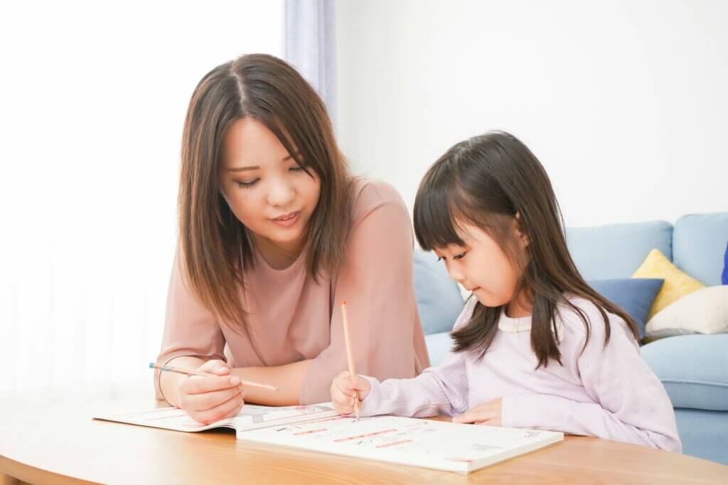 Mother working with her young daughter on school work