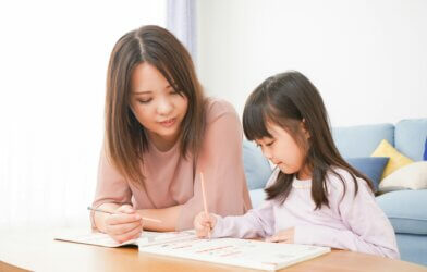Mother working with her young daughter on school work