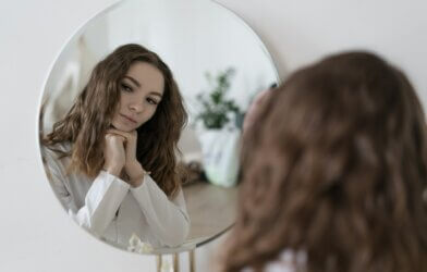 Teenage girl looking at herself in the mirror